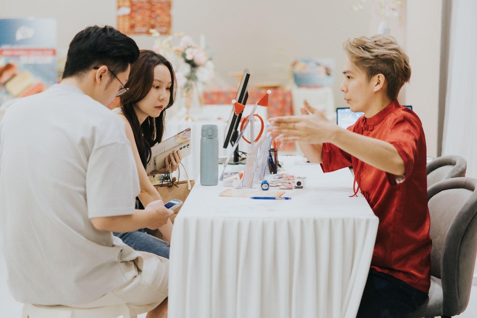 A couple consulting with a Promise Wedding Carnival vendor at an in-house fair